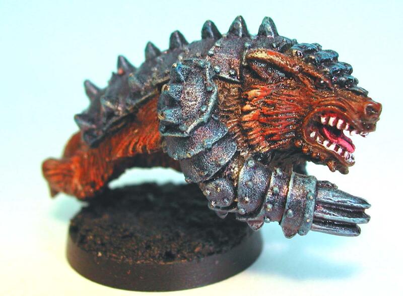 Painted miniature of a snarling red, spiked creature on a round base.