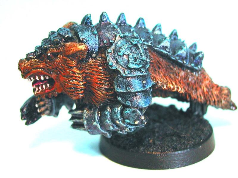Photograph of a painted spiky armored beast miniature on a black round base.