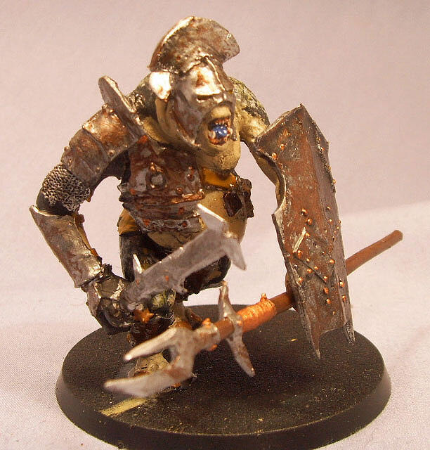 Painted fantasy miniature of an orc warrior with axe and shield on a black base