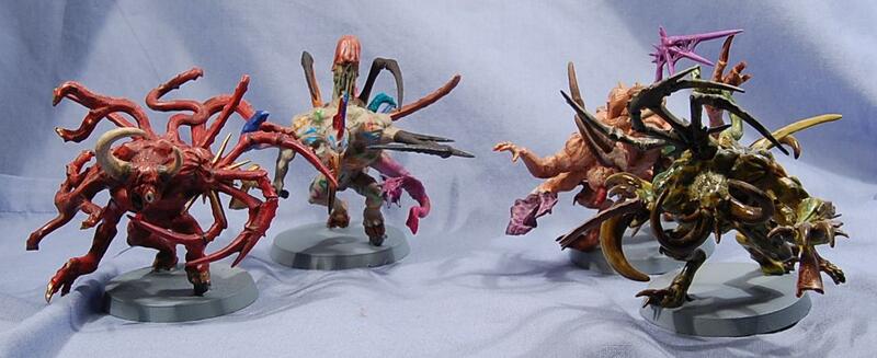 Three colorful spiky toy sculptures on a white cloth.