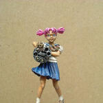 Photo of a painted miniature girl with pink pigtails holding a revolver cylinder.