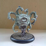 Painted miniature of a tentacled monster on a round base against a plain background.