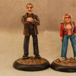 Two painted miniature figures, a man and a woman, standing on round bases.