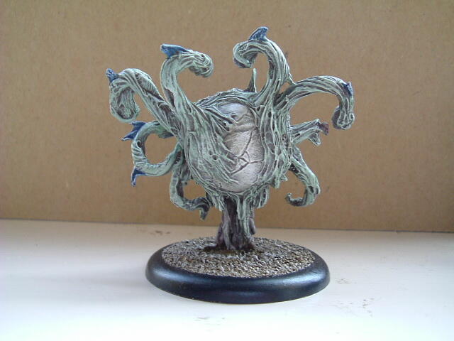 Silver fantasy creature figurine with curling necks on a round base.