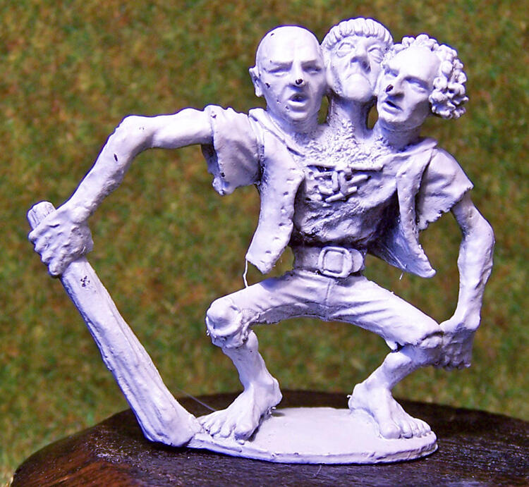 White figurine of two theatrical dancers posing with a large sword.