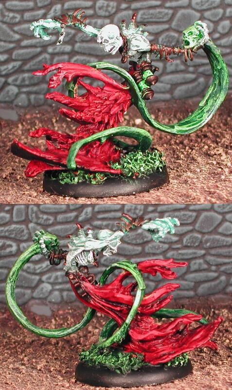 Painted miniature of a red dragon with a green tail, shown from two angles.