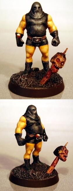Front and back views of a painted ogre miniature with yellow limbs and a severed head.