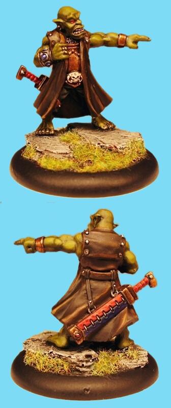 Front and back views of a painted fantasy warrior miniature on a sandy base.